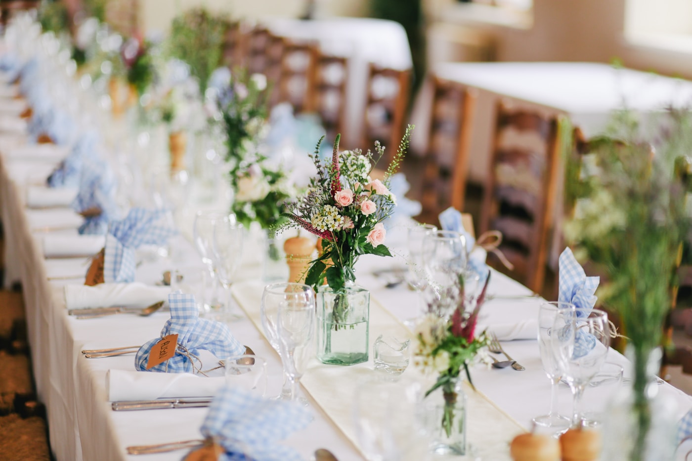Elegant wedding reception tablescape with tall floral centerpiece and candlelight